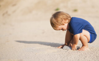 baby speelt in het zand