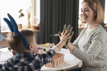childcare worker painting with kid